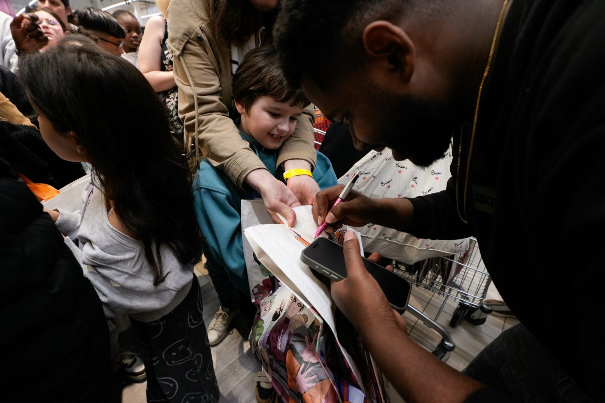 Un créateur signe un tote bag pour un jeune fan